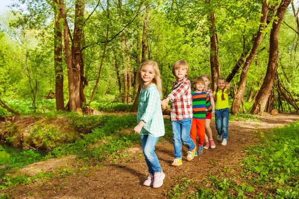 Kids holding hands in forest — Stock Photo, Image