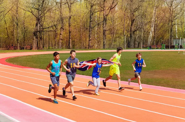 Sprinters adolescentes com bandeira britânica — Fotografia de Stock