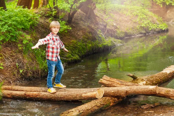 Joyeux garçon traversant la rivière — Photo