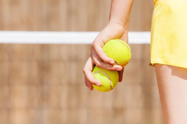 young girl holding tennis balls