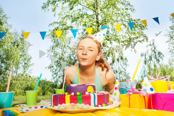 Chica soplando vela en pastel de cumpleaños — Foto de Stock