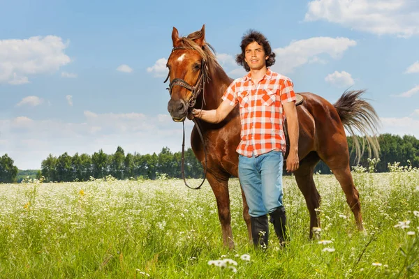 Hombre sosteniendo su caballo marrón —  Fotos de Stock