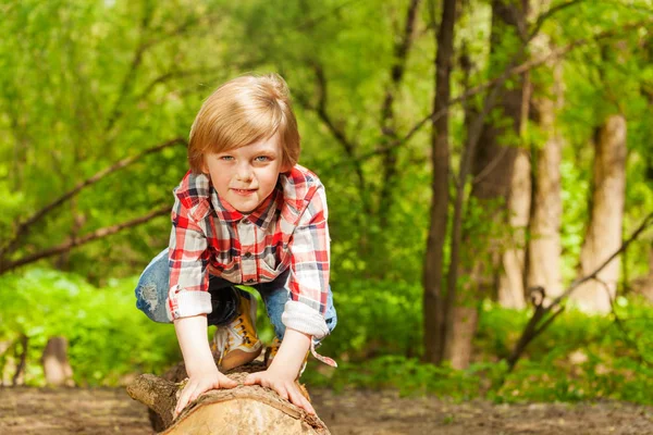 Young boy standing on log — Stock Photo, Image