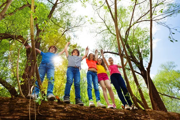 Dzieci stojąc na zwalone drzewo — Zdjęcie stockowe