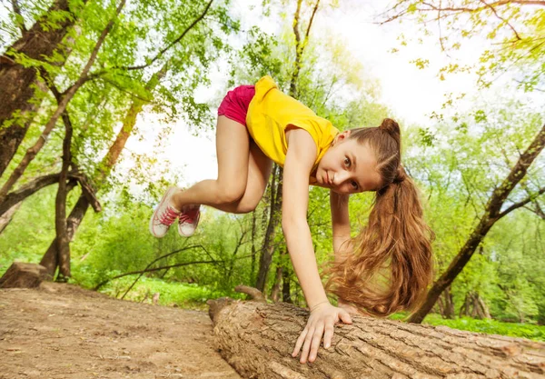 Girl jumping over log — Stock Photo, Image