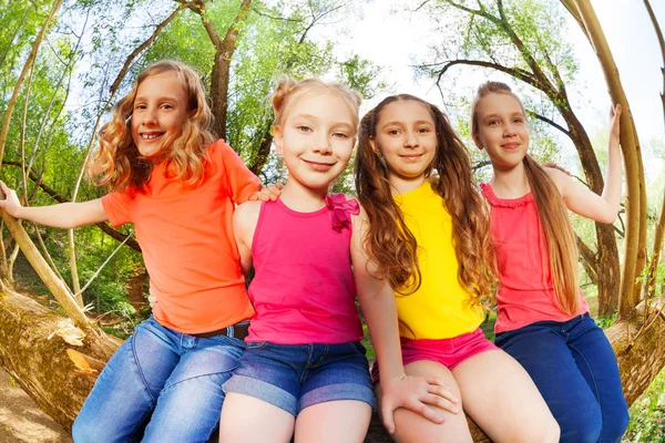 Mädchen sitzen auf umgestürztem Baum — Stockfoto