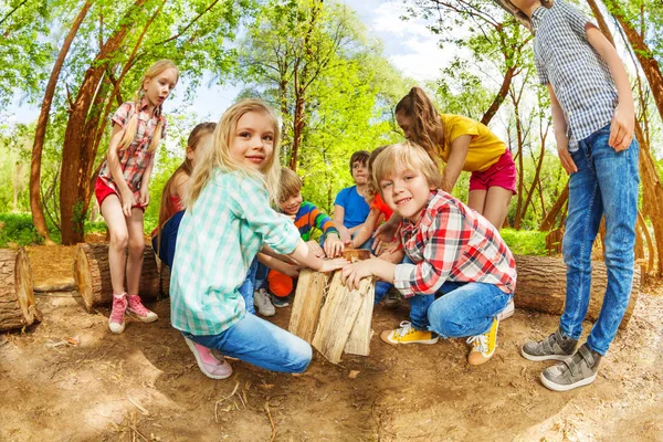 Niños jugando con troncos de madera — Foto de Stock