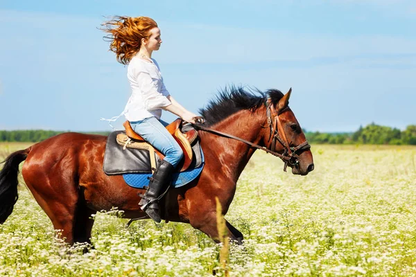Ung kvinne på galopperende hest – stockfoto