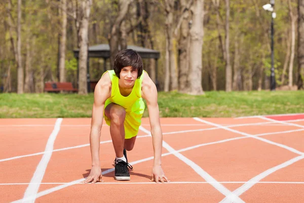 Menino em posição inicial na pista de corridas — Fotografia de Stock