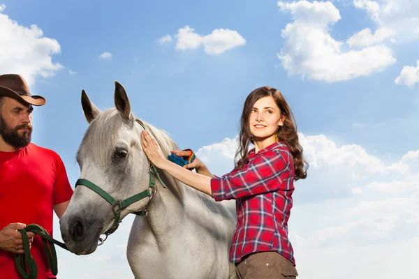 Mulher escovando seu cavalo branco — Fotografia de Stock