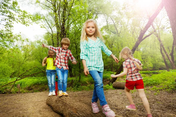 Niños felices caminando en el tronco — Foto de Stock