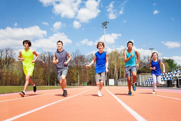 Teenage sprinters running on track — Stock Photo, Image