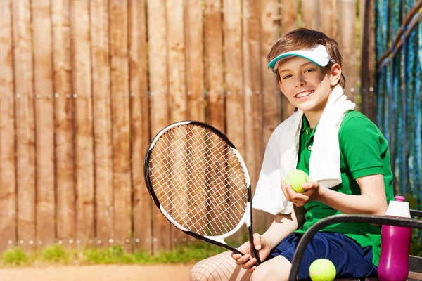 Jovem tenista sentado no banco — Fotografia de Stock