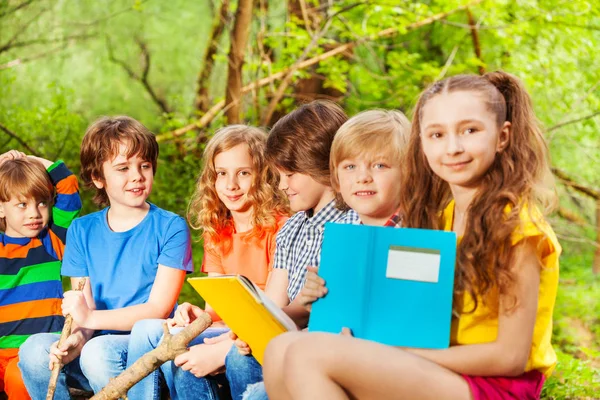 Kinder sitzen mit Büchern im Park — Stockfoto