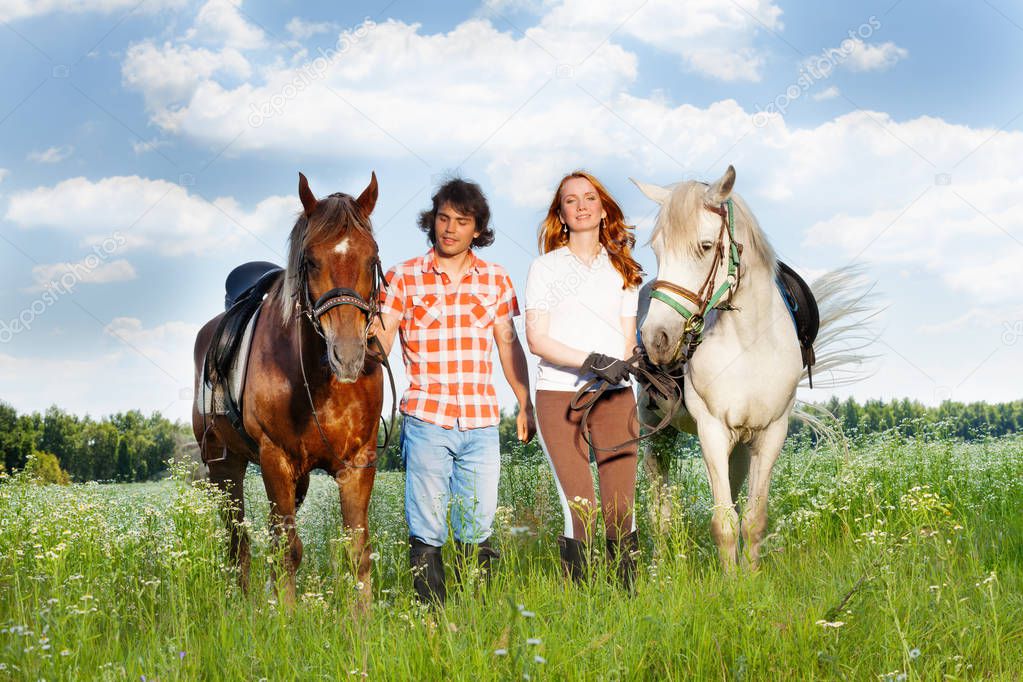 couple walking with horses