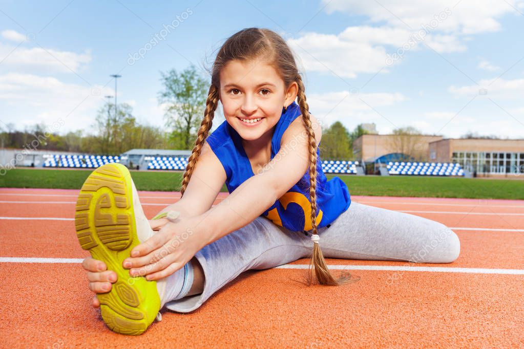 girl stretching legs on stadium