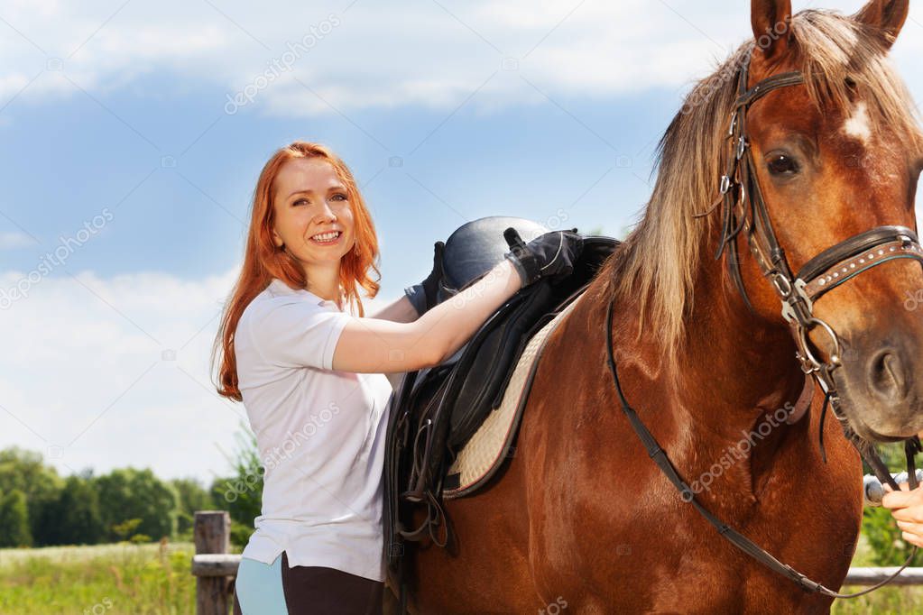 woman saddling horse