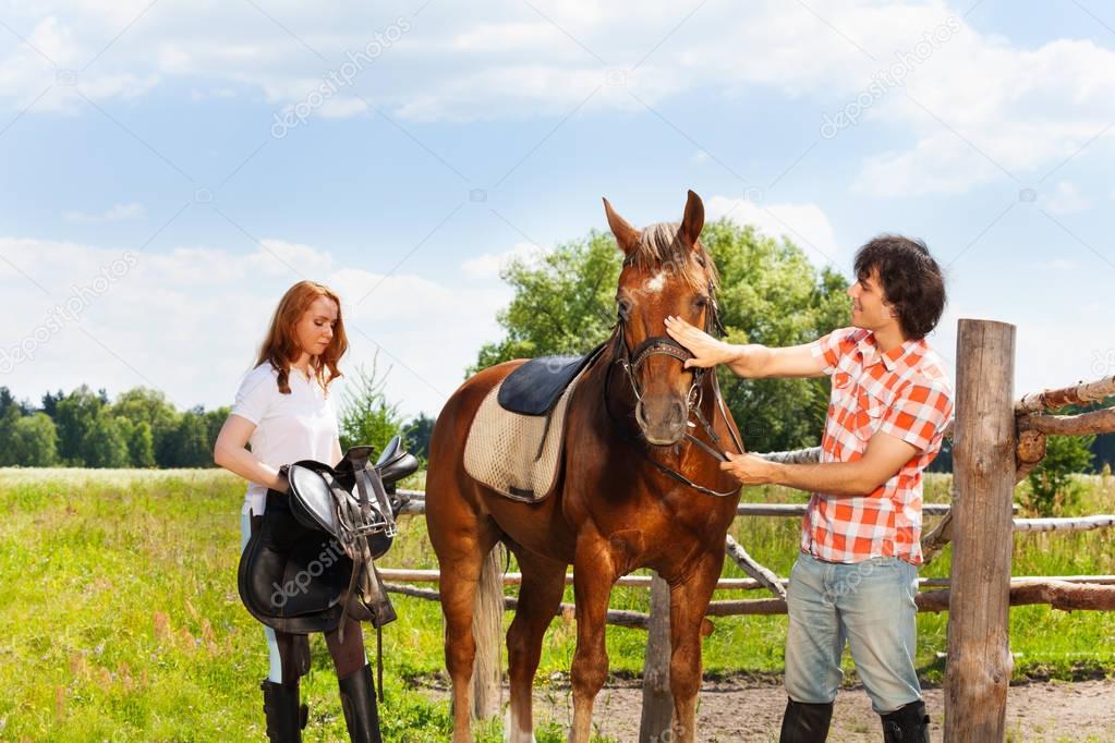 equestrians preparing horse for riding