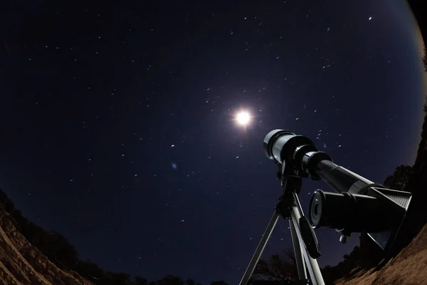 Телескоп, указывающий на ночное небо и звезды — стоковое фото