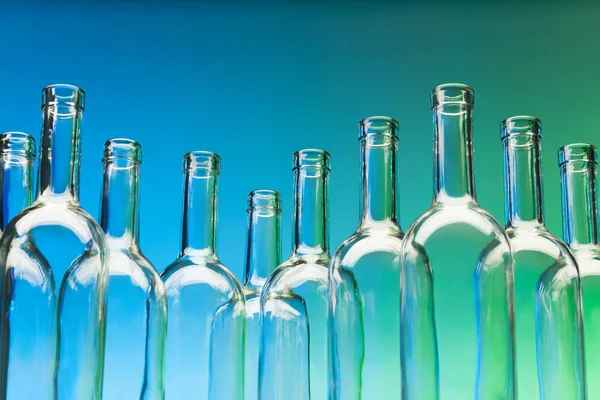 Скляні пляшки вина на синьому — стокове фото