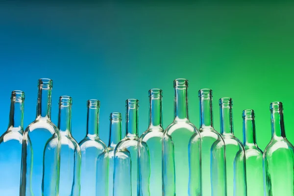 Скляні пляшки на синьому і зеленому — стокове фото