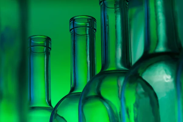 Glass wine bottles on green — Stock Photo, Image