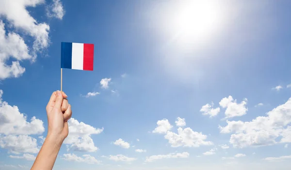 female hand holding French flag