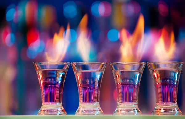 Vier shot glazen staande op bar — Stockfoto