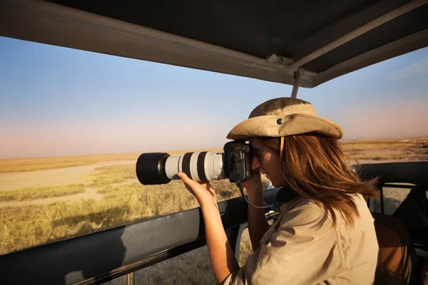 Vrouw nemen van foto's van safari jeep — Stockfoto