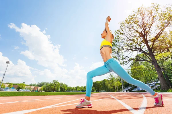 Frau macht Übungen auf Stadionbahnen — Stockfoto