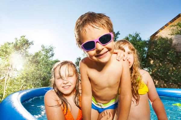 Crianças felizes brincando na piscina — Fotografia de Stock
