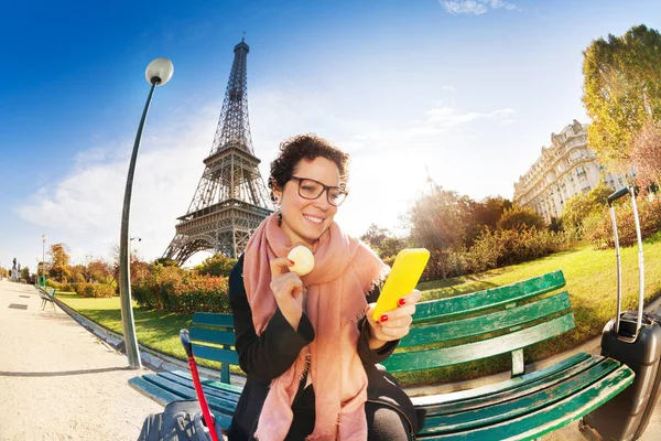 Mujer comiendo macaron cerca de la Torre Eiffel — Foto de Stock