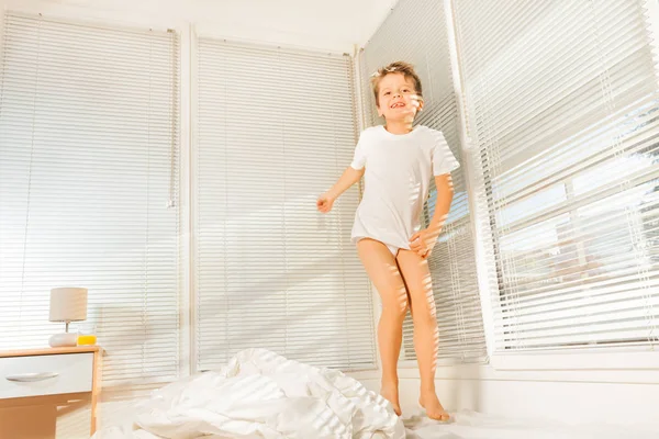 Little boy jumping on bed in morning — Stock Photo, Image