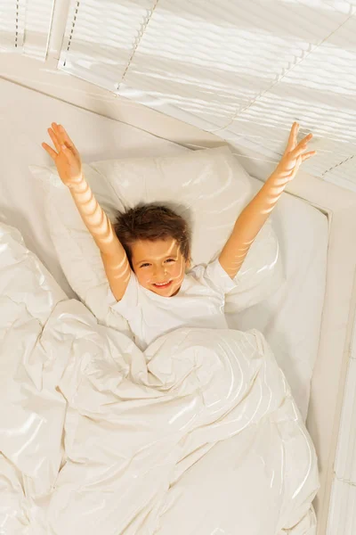 Malý kluk, probuzení v bílé ložnici — Stock fotografie