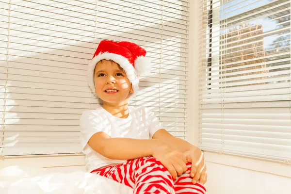 Chłopiec w kostium Santa marzy na łóżku — Zdjęcie stockowe