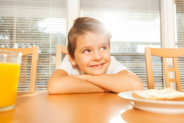 Niño sentado en la cocina y sonriendo —  Fotos de Stock