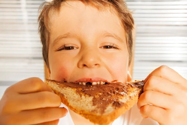Junge isst Toast mit Schokoladenaufstrich — Stockfoto