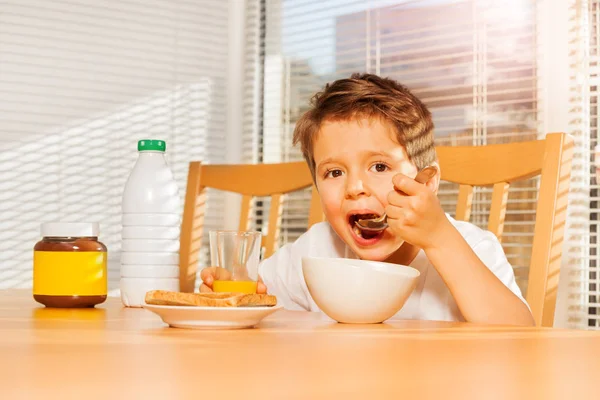 コーンフレークを食べる少年 — ストック写真