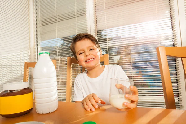 Niño pequeño sosteniendo vaso con leche —  Fotos de Stock