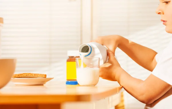 Pequeño niño vertiendo leche en un vaso —  Fotos de Stock