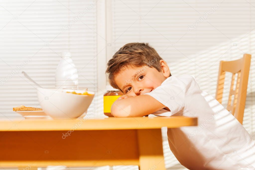 little boy having breakfast in kitchen