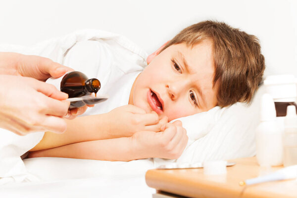 Женщина наливает антипиретический сироп
