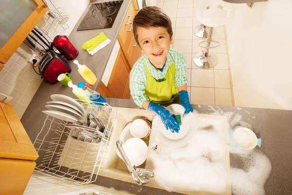 Мальчик мыть посуду — стоковое фото