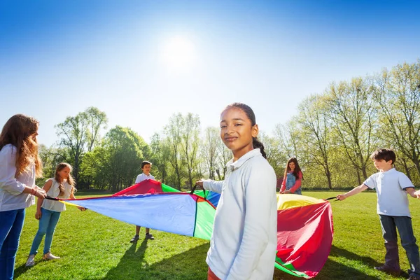 Niños jugando con alfombra de arco iris — Foto de Stock