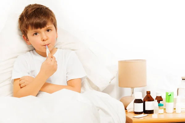 Sick boy with electronic thermometer — Stock Photo, Image