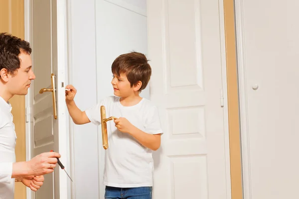 Ayah mengajari anak untuk memperbaiki pegangan pintu — Stok Foto