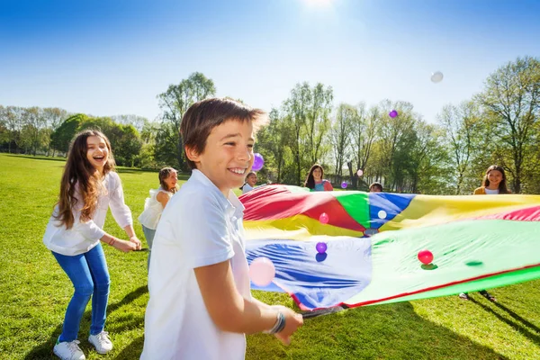 Gelukkige jonge geitjes met kleurrijke parachute — Stockfoto