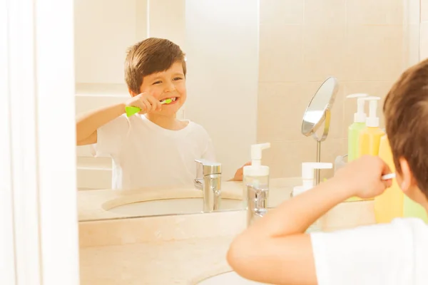 Menino no espelho durante a escovação dos dentes — Fotografia de Stock
