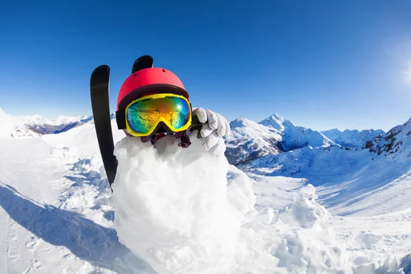 Snögubbe bär hjälm och mask — Stockfoto