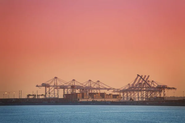 Puerto con grúas al atardecer — Foto de Stock